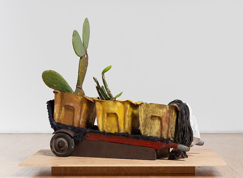 Photo: Vick Quezada, N-400 Hustle, 2023, ceramic buckets, cactus, soil, dolly, 54x22x40”