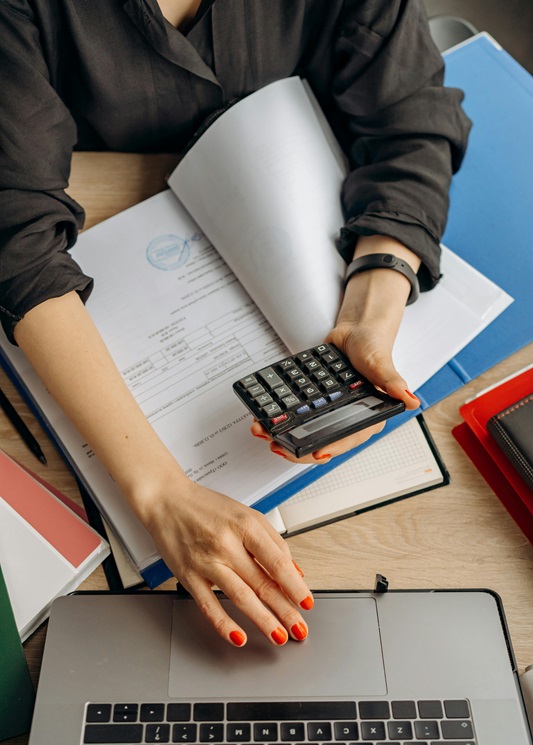 Person using calculator and laptop