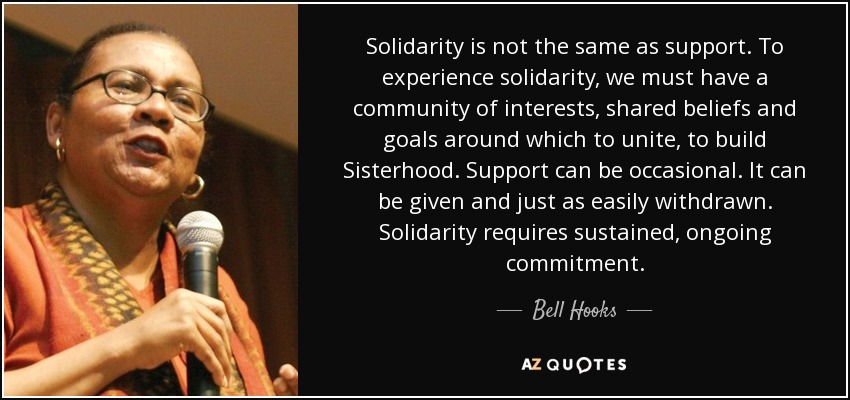 Alt-Text: The picture is one large rectangle split slightly left of center. On the left side of the rectangle is an image of bell hooks, a black feminist scholar speaking into a microphone, and looking out into a crowd. On the right side of the rectangle is a quote from bell hooks in white text on a black background from which reads “Solidarity is not the same as support. To experience solidarity we must have a community of interests, shared beliefs, and goals around which to unite, to build sisterhood. Support can be occasional. It can be given and just as easily withdrawn. Solidarity requires sustained ongoing commitment.”