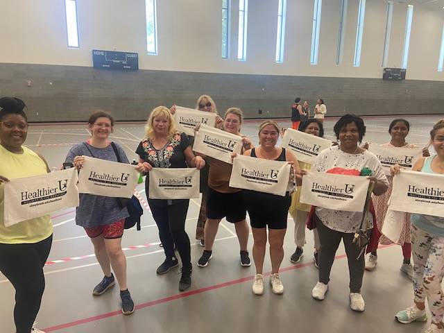 Attendees holding Healthier U signs and smiling