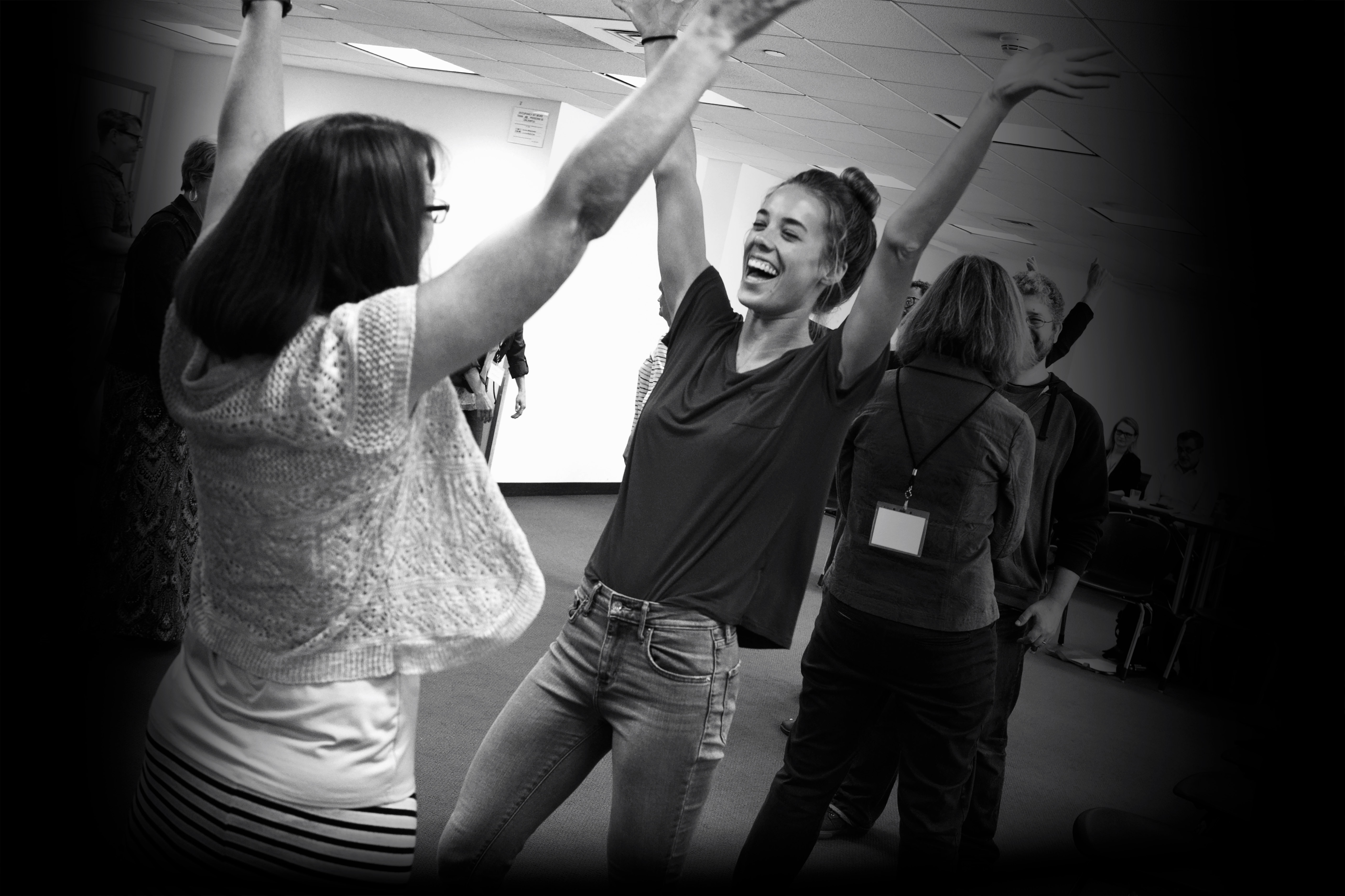 two women raise their arms over their heads and laugh