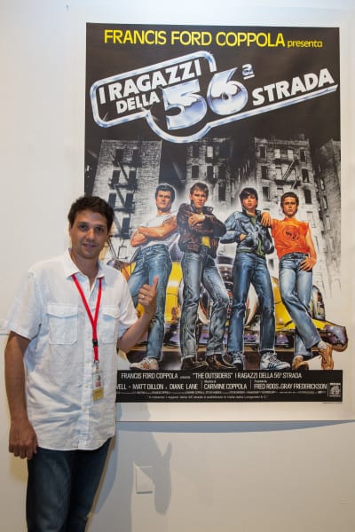 Long Island native and actor Ralph Macchio posing with the Italian film poster for the movie The Outsiders. Photo: Kenneth Ho